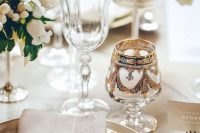 09 a chic white wedding tablescape with gold rimmed plates, white blooms, some gold-rimmed glasses and a vintage patterned one