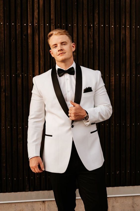 a chic black and white look with a tux with black lapels and other touches, a black bow tie, a white shirt and black pants