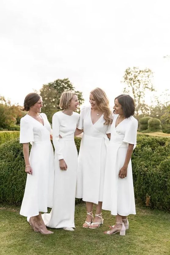 minimalist white midi bridesmaid dresses with short sleeves and V-necklines plus white and nude shoes for a minimal wedding