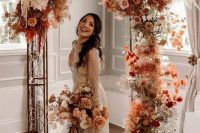 18 an incredible bright boho fall wedding arch with rust-colored and pink and blush roses, white orchids, pampas grass, rust-colored fall foliage just excites
