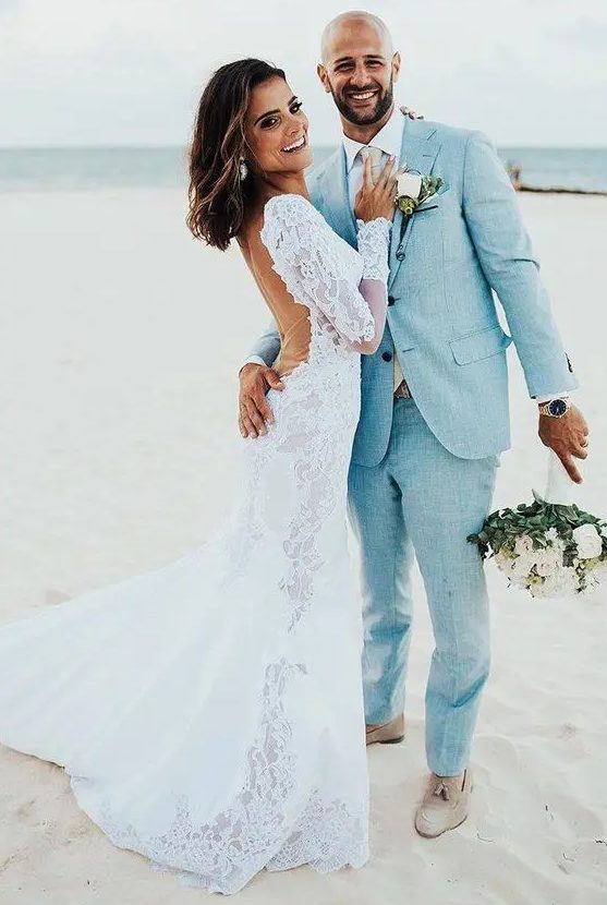 a beach groom's look with a light blue linen suit, a white shirt, a blush tie and neutral shoes is perfect and chic