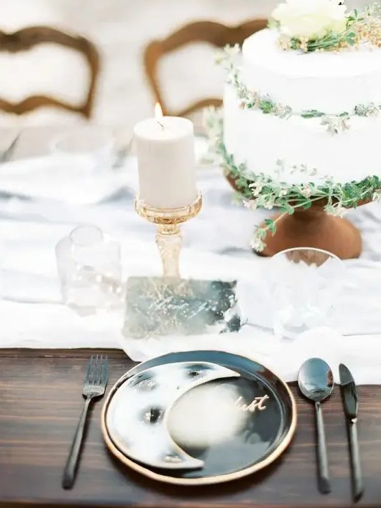 a celestial wedding place setting with black and white porcelain and a half moon, black cutlery, a candle and a card is wow