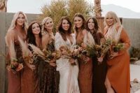 27 mismatching bridesmaid dresses in chocolate brown, orange, amber, with various necklines and looks for a boho wedding