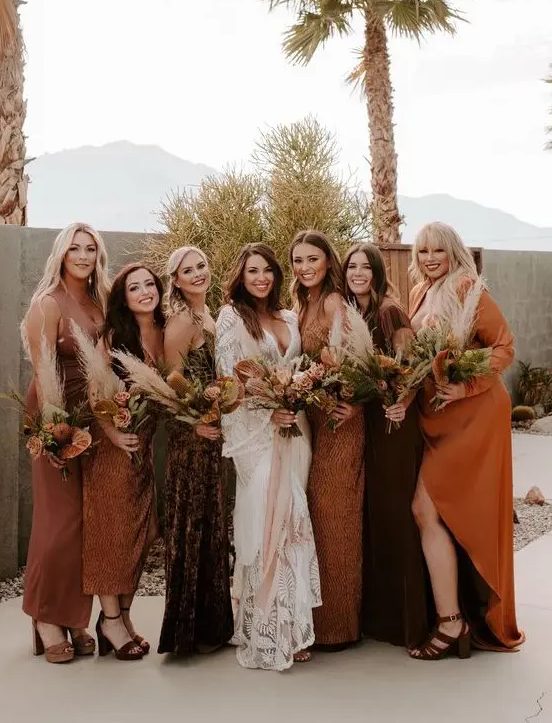 mismatching bridesmaid dresses in chocolate brown, orange, amber, with various necklines and looks for a boho wedding