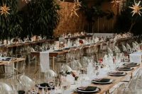 29 an elegant celestial wedding reception space with stars hanging down, clear chairs, black and white porcelain and black napkins