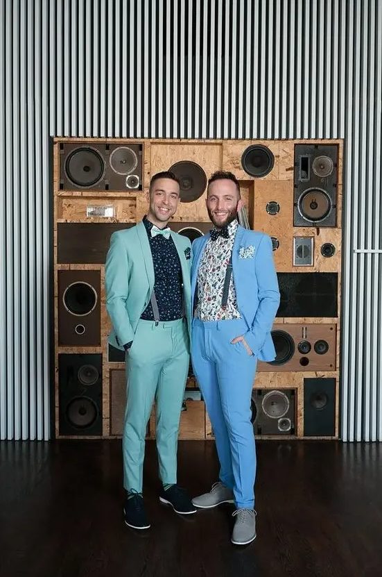 pastel grooms' looks with a green and blue suit, floral shirts, suspenders, bow ties and sneakers for a colorful wedding