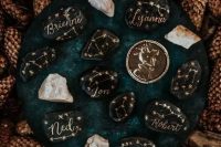 30 black pebbles with gold constellations used instead of wedding palce cards is a very cool DIY