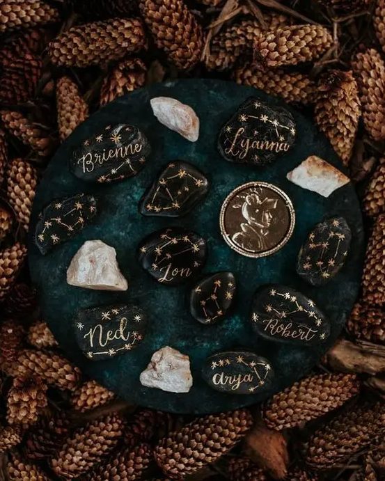 black pebbles with gold constellations used instead of wedding palce cards is a very cool DIY