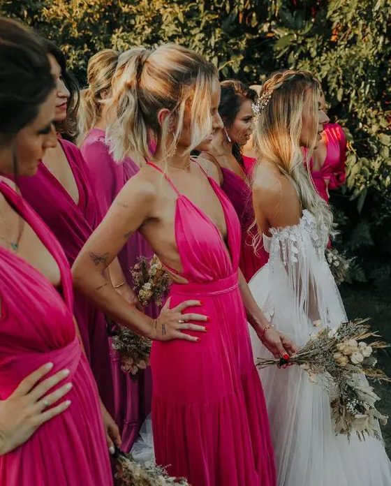 fantastic mismatching hot pink and fuchsia maxi bridesmaid dresses are ideal for rocking them at a tropical wedding