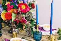 33 a bold Spanish-inspired wedding tablescape with hot pink, yellow and blue blooms, blue candles and glasses and purple napkins