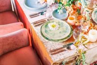 34 a bright wedding table setting with yellow, orange and white blooms, a peachy tablecloth and colorful plates, peachy candleholders and pink and orange blooms on the floor