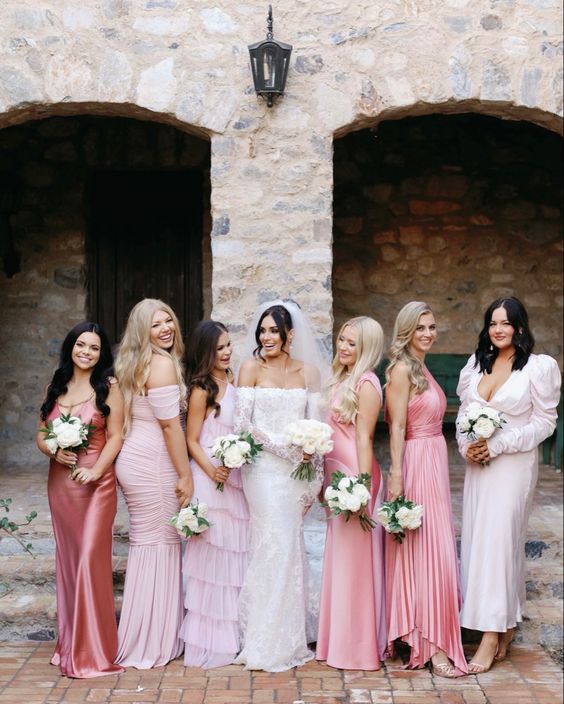 mismatching pale pink, light pink maxi and midi bridesmaid dresses with various kinds of detailing and silhouettes