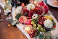 47 a super lush wedding table runner with white blooms, grapes, pears and eucalyptus, candles and a white fabric runner for a fall wedding