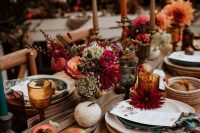 49 a bright fall wedding tablescape with bold blooms, fresh fruit and berries, colored candles and some colored glasses