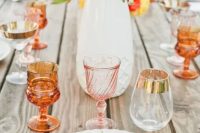 54 a summer wedding tablescape with patterned plates, bright blooms, amber and blush glassware