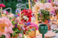 56 a colorful wedding table setting with printed plates, bright blooms and greenery and amber and green glasses
