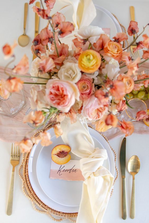 a beautiful coral and orange wedding place setting wiht peachy touches, a peachy card and a creamy napkin is wow