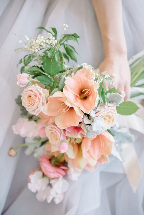 a beautiful peachy and white bloom wedding bouquet with greenery and lily of the valley is romantic