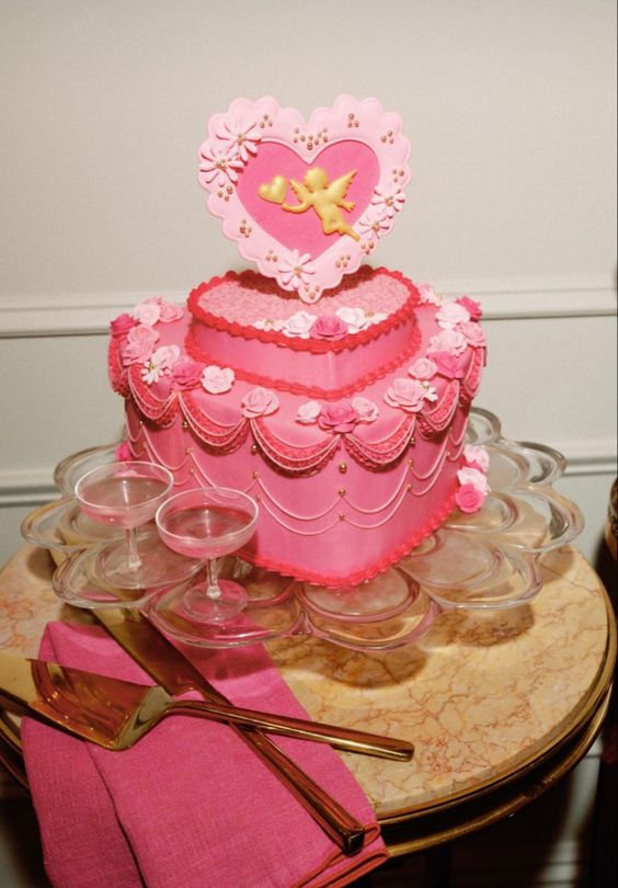 a bold pink heart-shaped wedding cake with beads and sugar detailing plus a heart-shaped cake topper