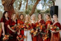 a bridal party dressed in burgundy, red and orange is amazing for a bright and colorful fall wedding