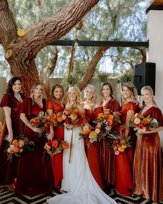 a bridal party dressed in burgundy, red and orange is amazing for a bright and colorful fall wedding