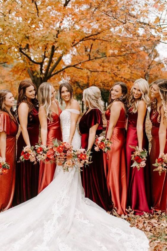 a bridal party in the shades of orange, red and burgundy is a gorgeous solution for a bright fall wedding