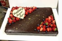 a chocolate sheet wedding cake topped with fresh berries and a heart is a lovely idea for a wedding