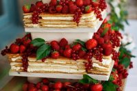 a delicious tiered square millefoglie topped with lots of fresh berries and leaves is cool for summer