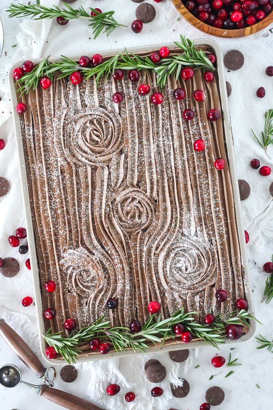 a fantastic Yule log sheet wedding cake topped with herbs and cranberries is amazing for a Christmas wedding