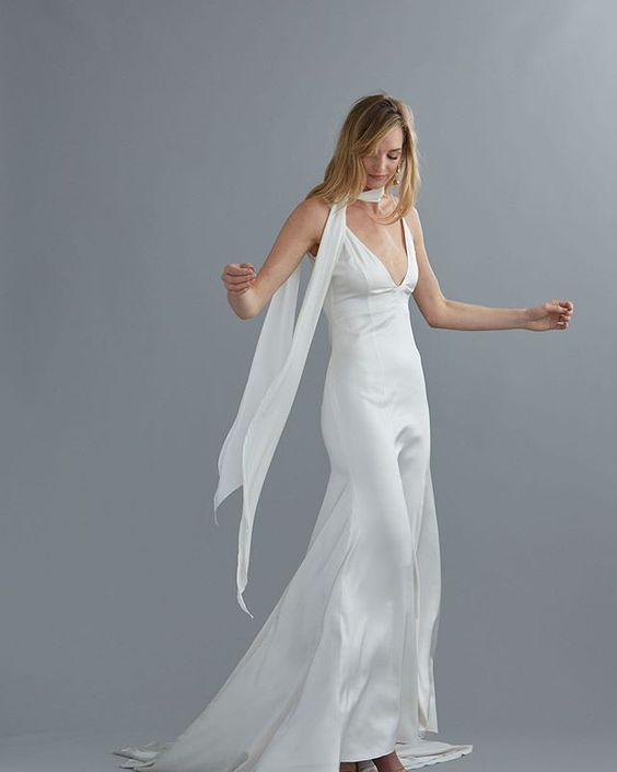 a fitting strap silk wedding dress with a depe neckline and a scarf for a flowy and ultra-modern bridal look