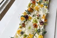 a gorgeous long sheet wedding cke topped with fresh blooms, twigs, leaves and twigs is a great idea for a fall garden wedding