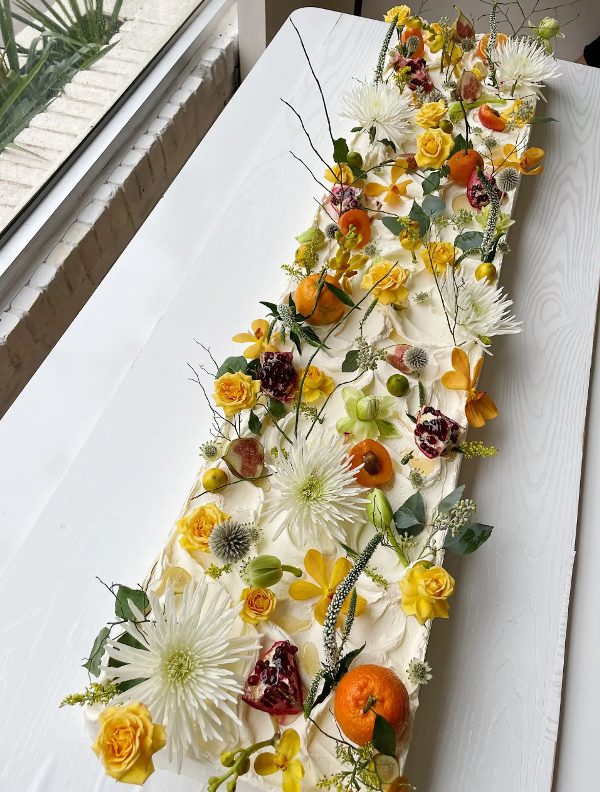 a gorgeous long sheet wedding cke topped with fresh blooms, twigs, leaves and twigs is a great idea for a fall garden wedding