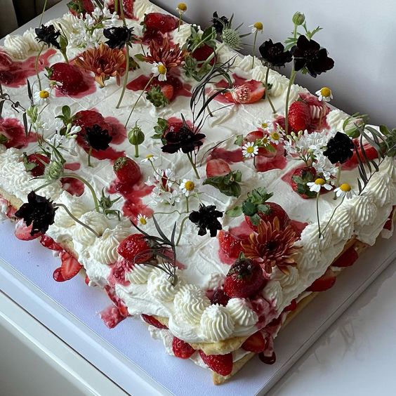 a gorgeous sheet wedding cake topped with fresh berries and blooms is a lovely idea for a modern garden wedding