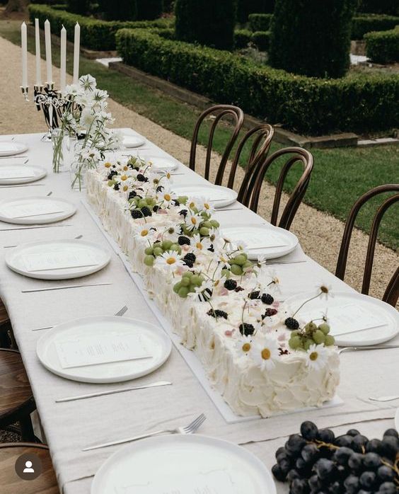 a gorgeous white textural sheet wedding cake topped with grapes, blackberries, fresh blooms is a cool idea for a summer wedding