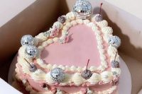 a jaw-dropping pink lambeth heart-shaped wedding cake with silver cherries and disco balls on top is amazing