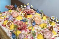 a jaw-dropping sheet wedding cake topped with pink and blue flwoers, dried and fresh citrus is a fantastic idea for a summer wedding