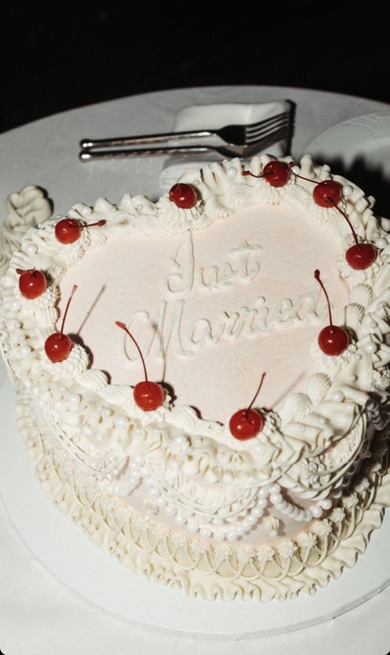 a lambeth heart-shaped wedding cake with some sugar details and some cherries on top is a cool idea