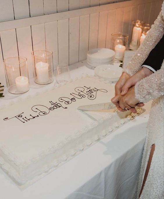 a lovely white sheet wedding cake with chocolate calligraphy on top and sugar icing is a cool idea for a modern and a bit kitschy wedding