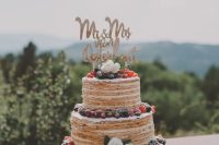 a millefoglie wedding cake styled as a usual tiered wedding cake, topped with berries, blooms and a calligraphy topper