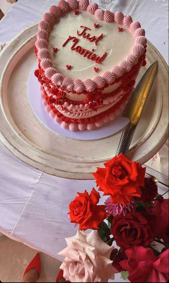 a neutral, pink and red heart-shaped lambeth wedding cake with sugar detailing and calligraphy is a cool and catchy idea