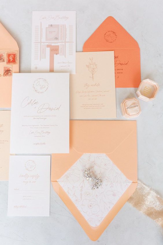 a peach and orange wedding stationery suite with prints and calligraphy is a cool and catchy idea for a bold wedding