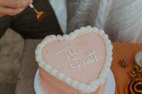 a peachy pink heart-shaped wedding cake with sugar details is a lovely idea for a modern wedding