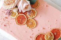 a peachy pink sheet wedding cake with fresh blooms, dried citrus, greenery and pearls is a fantastic idea for a wedding