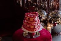 a pink heart-shaped wedding cake with sugar details and some calligraphy on top is a cool idea for a bold wedding