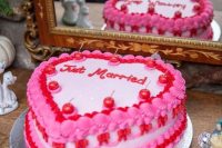 a red, hot pink and white heart-shaped wedding cake topped with cherries is a cool and kitschy wedding idea