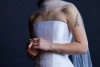 a refined modern bridal look with a strapless wedding dress and a sheer scarf with pearls all over