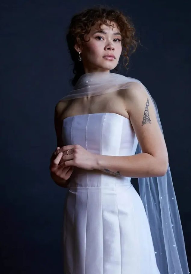 a refined modern bridal look with a strapless wedding dress and a sheer scarf with pearls all over