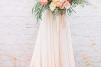 a refined wedding dress with a lace bodice and sleeves and a white to peachy pink skirt with a train looks beautiful