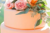 a sleek and plain peach wedding cake with peach and pink blooms and greenery is amazing for a summer wedding