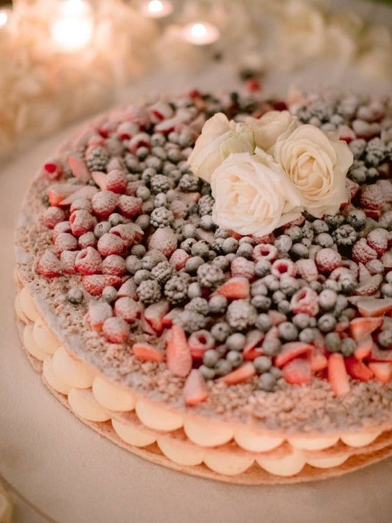 a small round millefoglie wedding cake topped with fresh berries, sugar powder and white roses is a brialliant alternative to a usual wedding cake